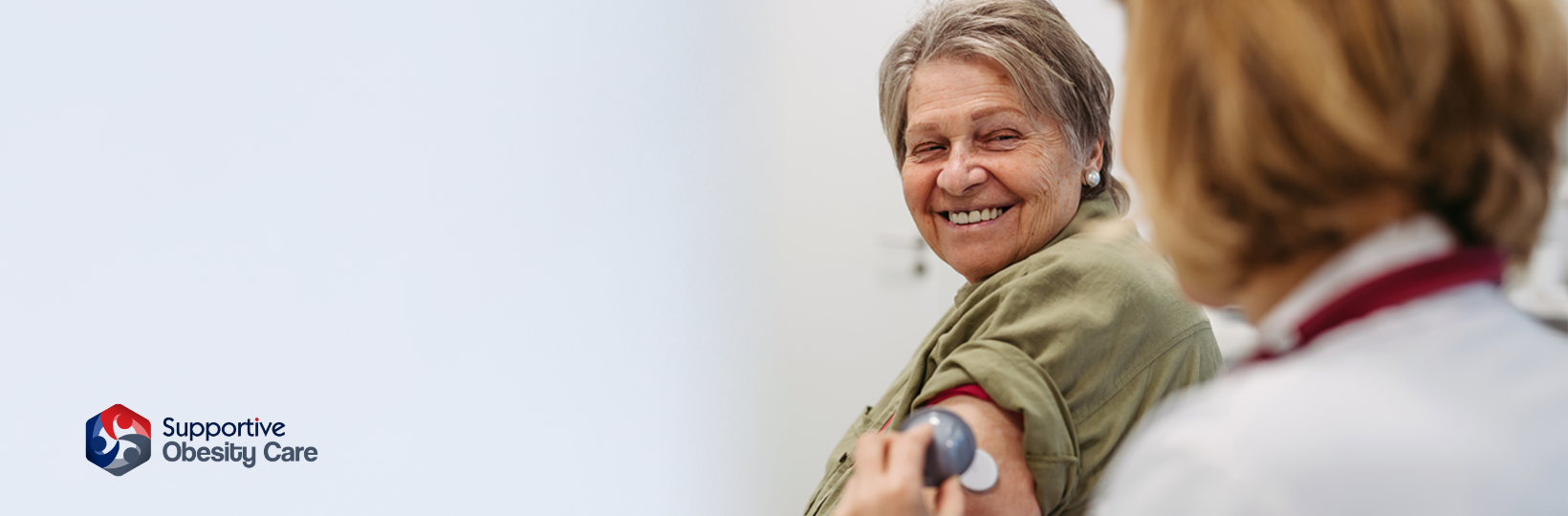 Doctor shows smiling older patient how to use Continuous Glucose Monitor